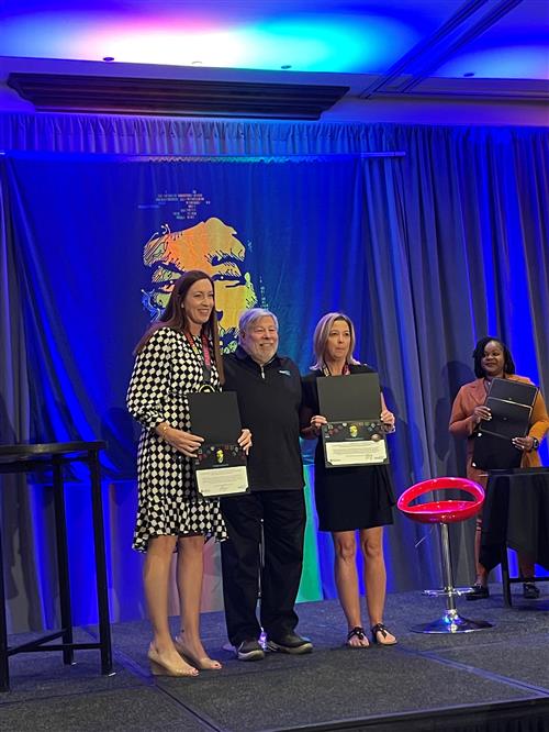 Principal Kane and WOZ teacher Ms. Keefe receiving a WOZ award